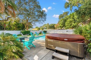 Un jardin avec un jacuzzi, une piscine et un espace salon extérieur.