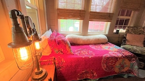Een gezellige kamer met een bed, een vintage lamp en een raam met uitzicht.