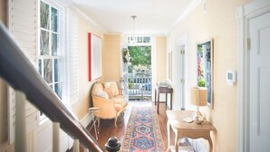 A hallway with a sofa, a rug, and a table with a lamp. - Spend the Night in an Historical, Luxury Downtown Home by Lucky Savannah (Savannah)