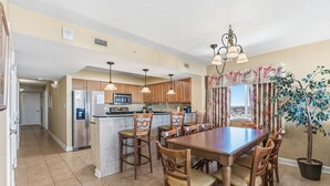A spacious kitchen with wooden cabinets, a central island, and pendant lighting. - Luxury condo, across the street from the beach + Free Attraction Tickets! (North Myrtle Beach)