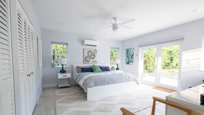A bedroom with a bed, nightstand, lamp, and a ceiling fan. - Beach, Art District, Shopping, Restaurants! Best Spa in Delray! (Delray Beach)