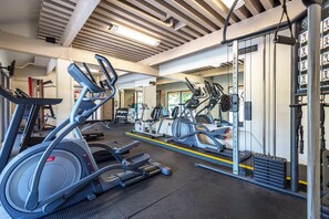 A gym with treadmills, elliptical machines, and weight equipment.