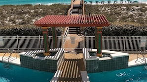 A pool area with a gazebo, a view of the beach, and a lifeguard tower. - Wilson's Beach Dream: Gulf Front 5 Star 3BR 3Bath with Beach Service (Navarre)