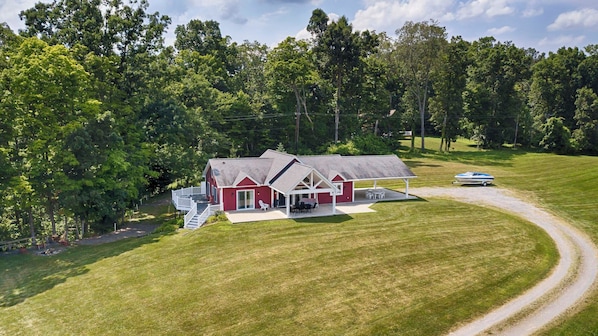 A red house with a covered patio and a boat dock. - Rapalee Retreat - Wine and Lake Lovers Take Notice! (Himrod)