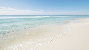 A beach with clear water and a pier in the distance. - Renovated with Gulf View Free Beach Chairs, Golf, & Activities Daily! (Panama City Beach)