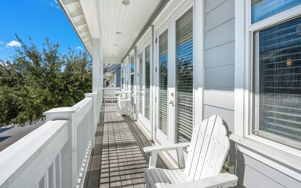 A covered porch with white railings, a wooden deck, and a row of windows with blinds. - Prominence on 30A + Pool, Bikes & Nearby Shopping (Inlet Beach)