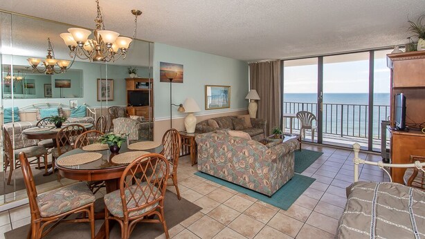 A spacious living area with a dining table, chairs, sofas, and a balcony with a view of the sea. - ONE BEDROOM CONDO TO DIE FOR  Royal Garden 803 (Murrells Inlet)
