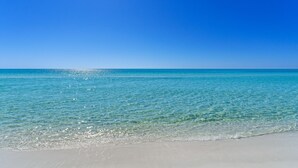 Ein Strand mit klarem türkisblauem Wasser und einem strahlend blauen Himmel.