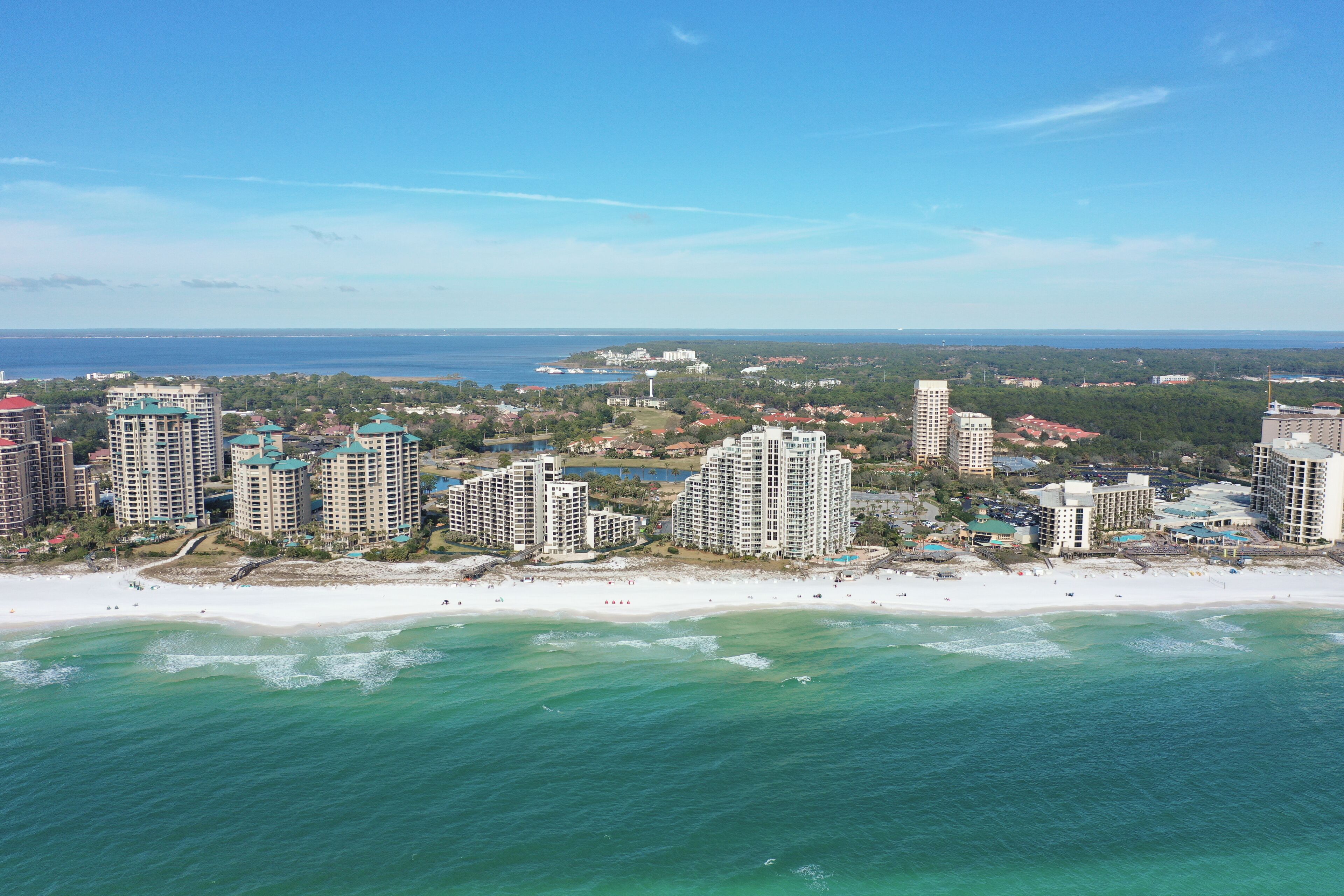A coastal cityscape with high-rise buildings, a beach, and a view of the ocean.