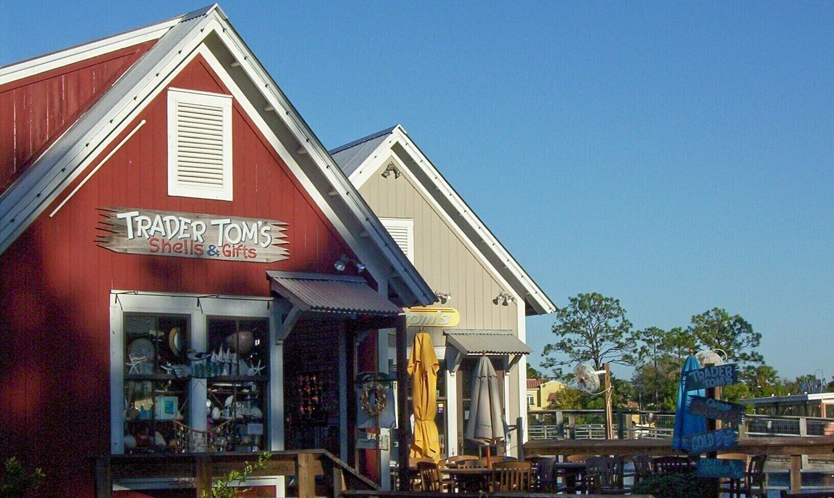 A red building with a sign reading "Trader Tom's Shells & Gifts."