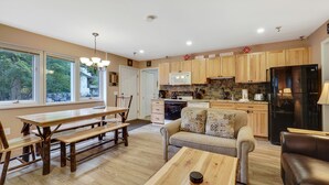 A spacious living area with a wooden dining table, a sofa, and a coffee table.