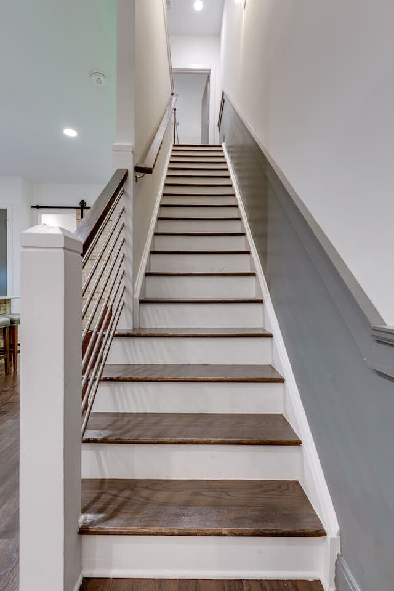 A staircase with wooden steps and white walls, leading to a landing area.
