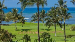 Ein Golfplatz mit freiem Blick auf den Ozean und Palmen.