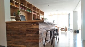 A modern kitchen with wooden accents, a built-in bar area, and a seating space with a view. - Wangshan Travelling With Hotel (Lijiang)