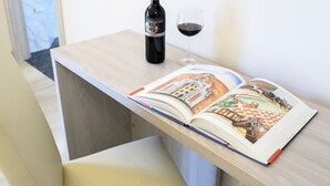 A book open on a table with a bottle of wine and a glass of wine beside it. - Domus il Palio B&B (Siena)