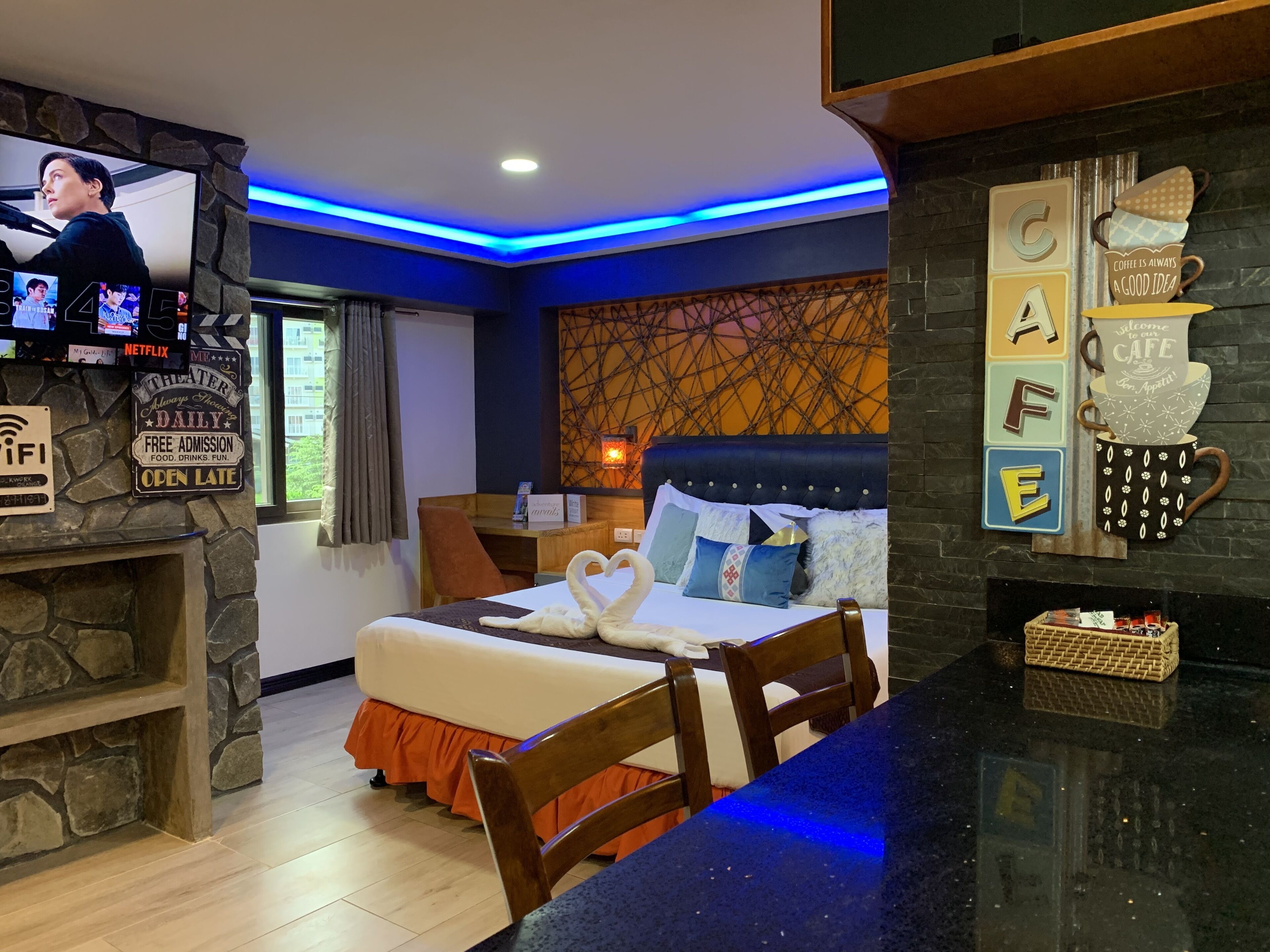 A hotel room with a bed, a TV, a desk, and a coffee station.