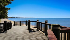 A wooden pier with railings leading to a beach. - Hamptons at The Bay (Deception Bay)