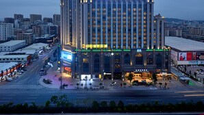 A multi-story hotel with a prominent sign for the Sunshine Glory Plaza Hotel. - Menshine Gloria Plaza Hotel Shantou (Shantou)