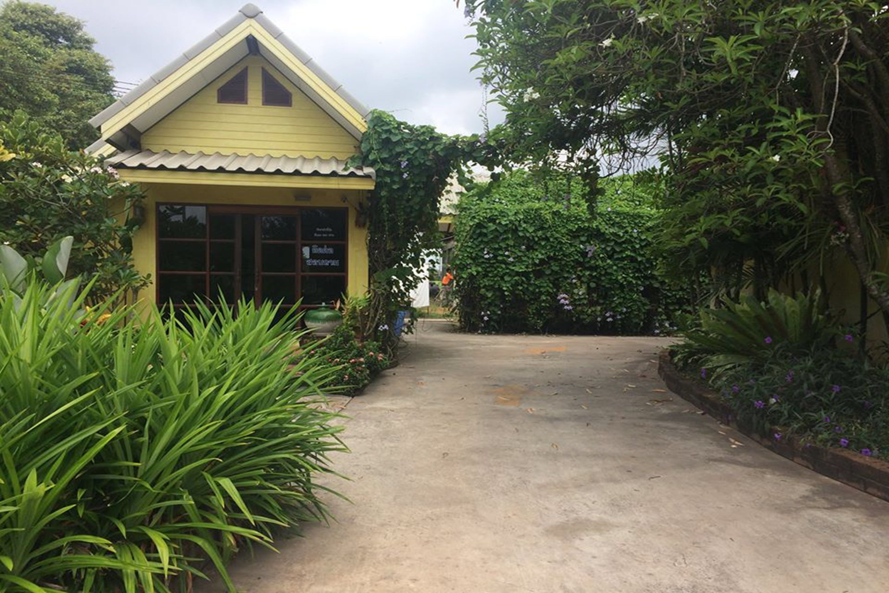 A yellow building with a tiled roof and a sign that reads "Bungalow Suites."