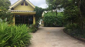 A yellow building with a tiled roof and a sign that reads "Bungalow Suites."