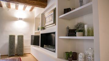 Una sala de estar moderna con chimenea, estanterías blancas y adornos decorativos.