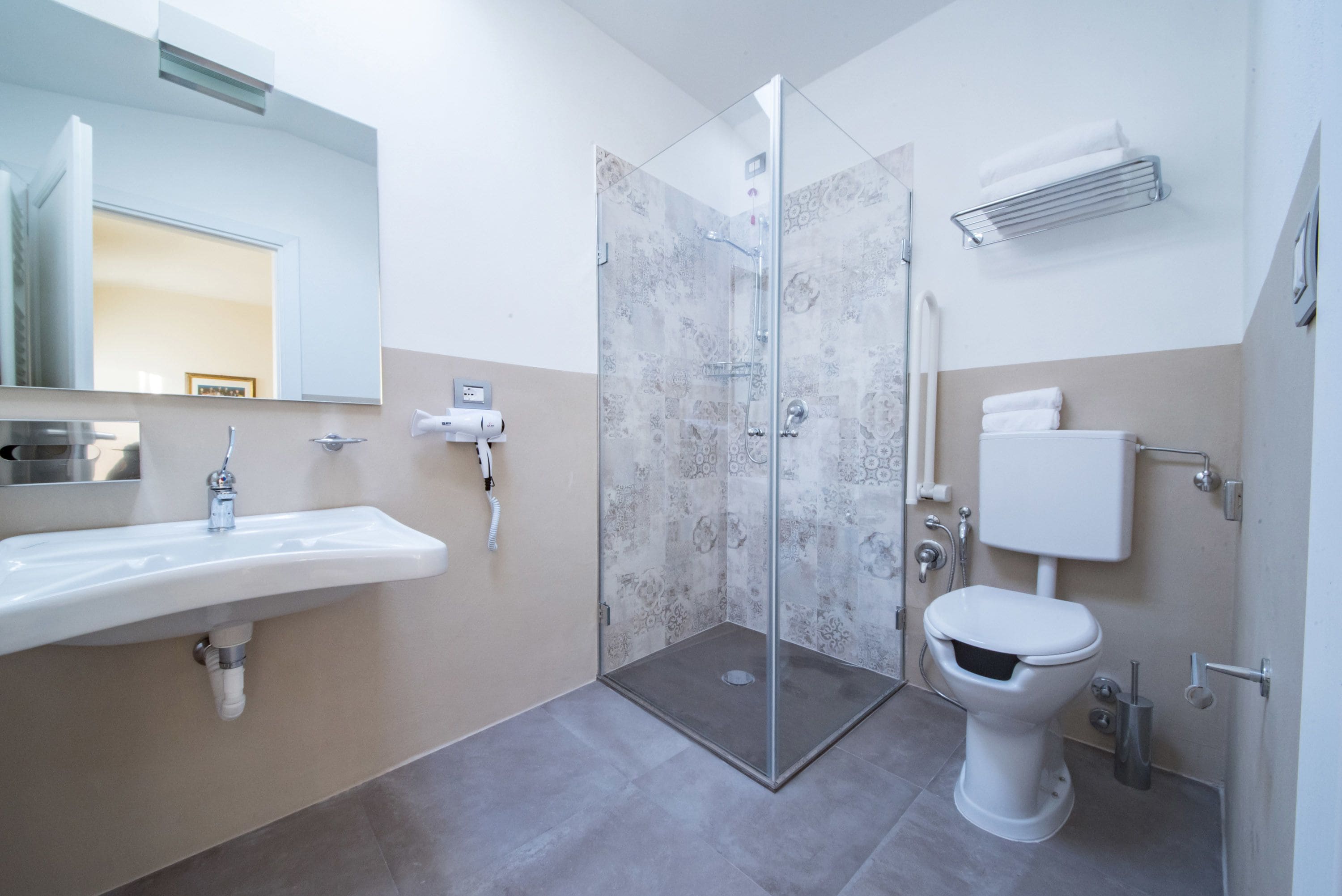 A modern bathroom with a glass-enclosed shower, a white sink, and a toilet.