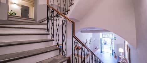 A staircase with a wrought iron railing leading to a second floor.