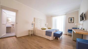 Une chambre à coucher comprenant un lit, des tables de chevet, un bureau et une chaise.