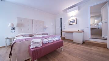 Ein Hotelzimmer mit Bett, Nachttisch, Lampe und Spiegel.