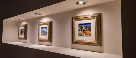 A gallery wall with framed artworks displayed on a white ledge.