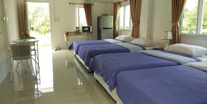 A hotel room with three beds, a small table with chairs, a refrigerator, and a window with curtains. - Baan Auemdao Resort (Khao Kho)