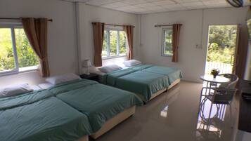 A hotel room with two beds, a small table, and a chair.