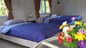 Ein Hotelzimmer mit zwei Betten, einem Nachttisch, einer Lampe und einem Fenster mit Vorhängen.