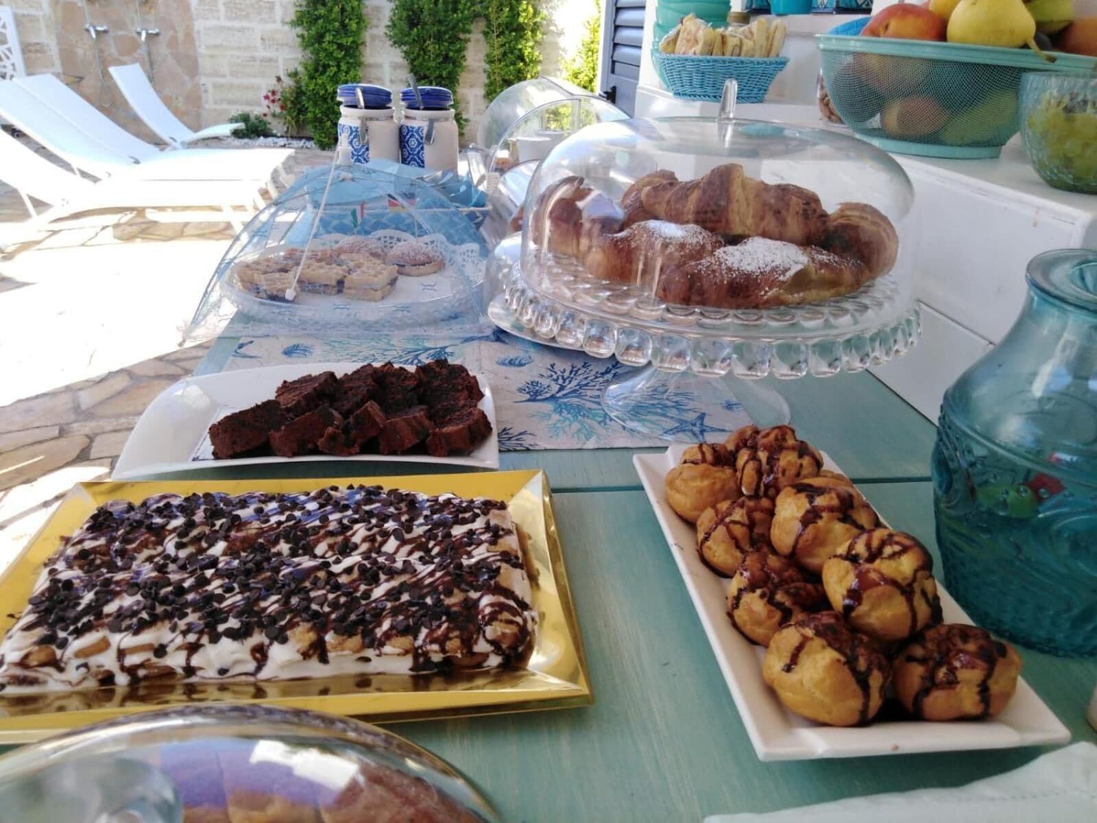 Una mesa de buffet con diversos postres, incluyendo pasteles, brownies y repostería.