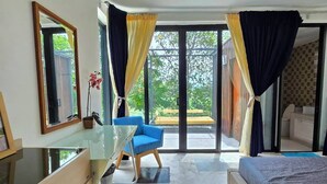 Une chambre moderne avec un lit, un bureau et une chaise. Une grande fenêtre, ornée de rideaux, offre une vue sur l’extérieur.