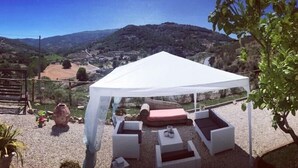 A covered outdoor seating area with white wicker furniture and a white canopy, overlooking a scenic hillside. - Villa Rosa (Agropoli)
