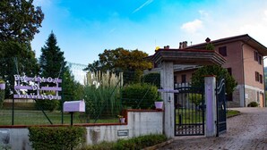 Une entrée fermée par un portail, sur laquelle est apposée une enseigne indiquant « BE AMOR DI LAVANDA », et un bâtiment doté d’une façade en pierre et d’un balcon.