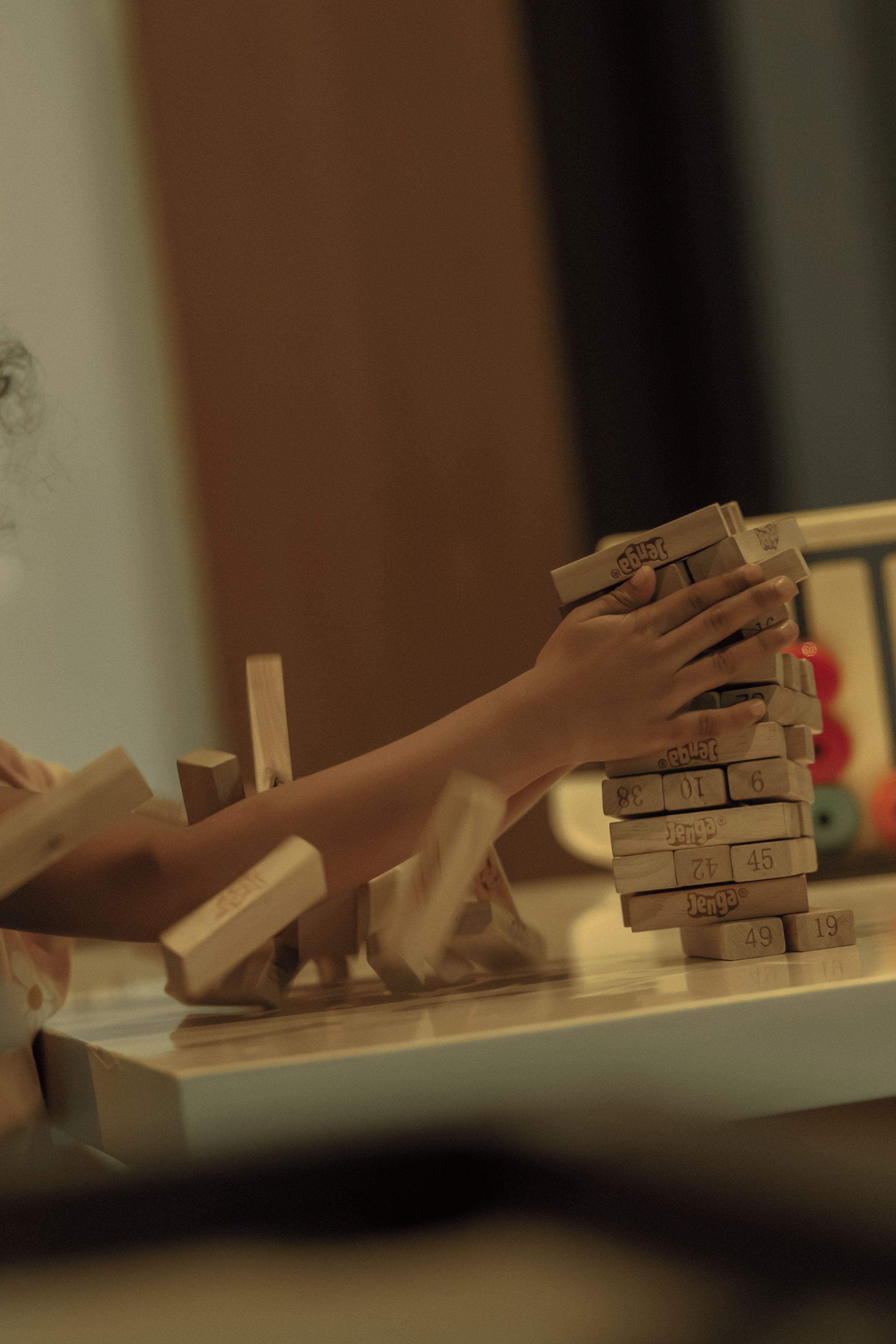 Eine Person spielt ein Holzklötzspiel mit nummerierten Klötzen.