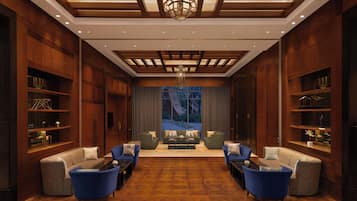 A spacious lobby with a central seating area, wooden paneling, and a large window providing a view.