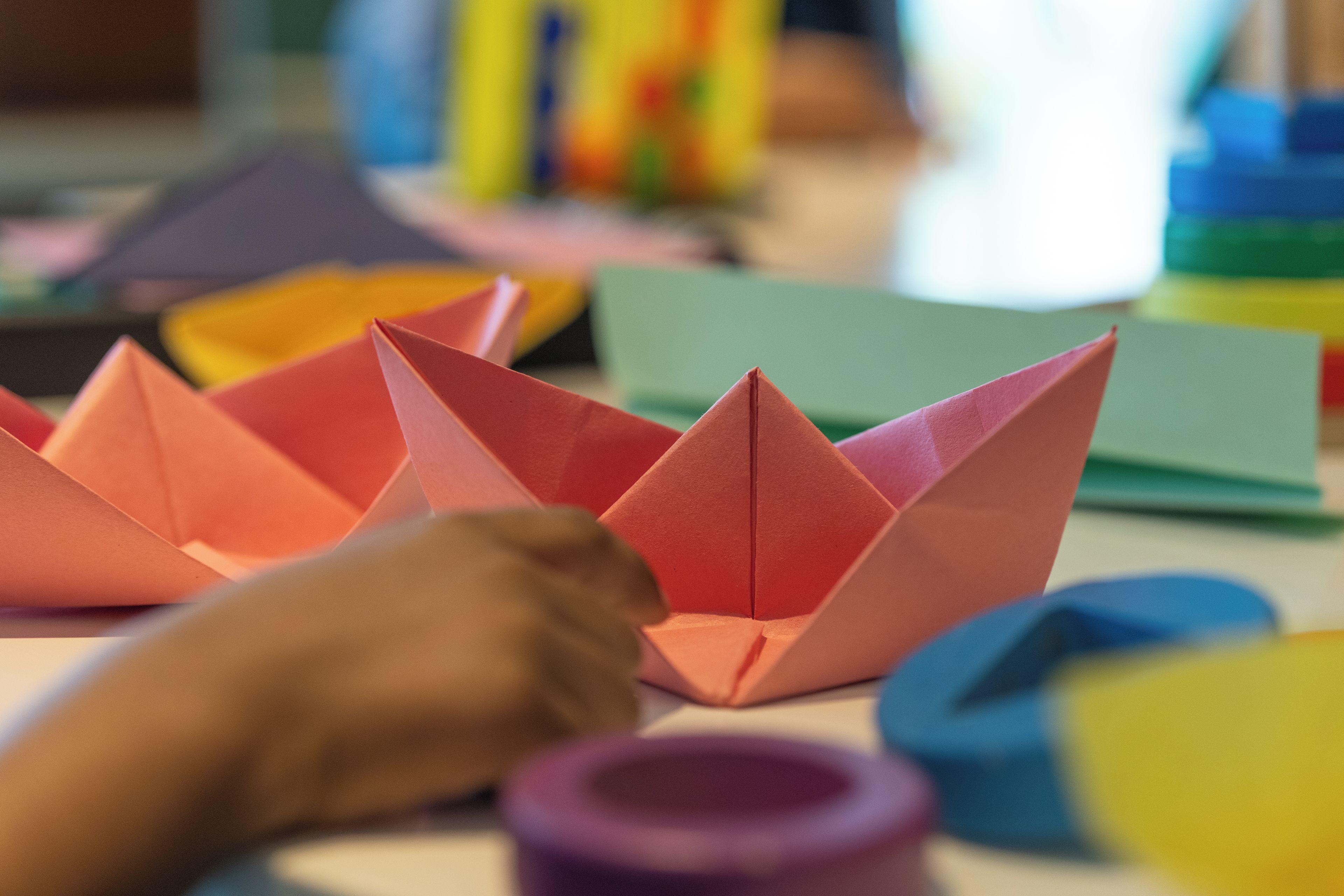 Un conjunto de barquitos de papel hechos con origami sobre una mesa.