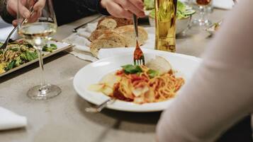 Un tavolo imbandito con piatti di cibo, bicchieri di bevande e posate.