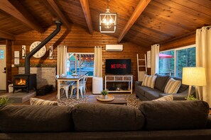 Tunnelmallinen olohuone, jossa on takka, televisio ja sohva.