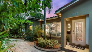 A house with a stone-paved entrance, a number '1441' above the door, and a well-maintained garden with various plants. - Private Tropical Escape Near Fort Lauderdale Beaches & Dining! (Fort Lauderdale)