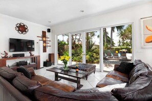 A modern living room with a leather sofa, a coffee table, and a flat-screen TV.