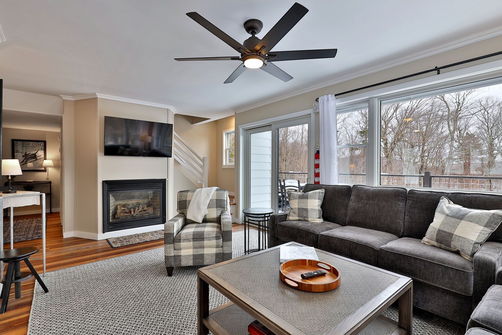 A living room with a fireplace, a sofa, a coffee table, and a ceiling fan.