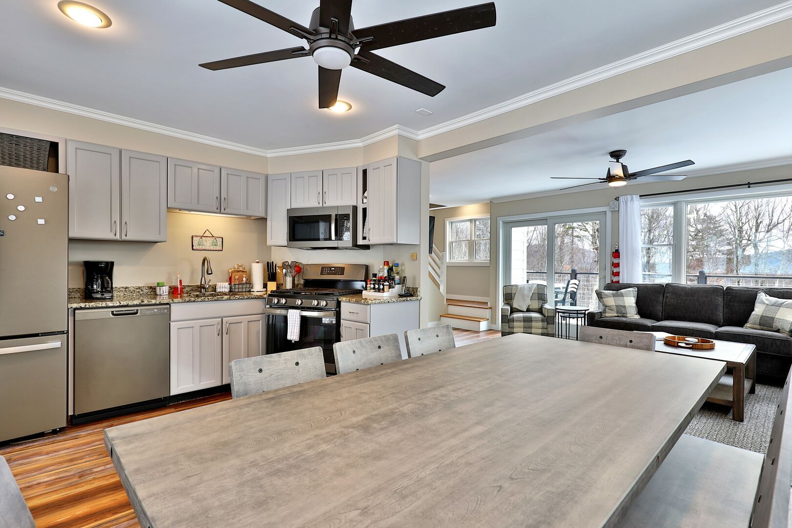 A modern kitchen with a central island, built-in appliances, and a dining area with a large table.