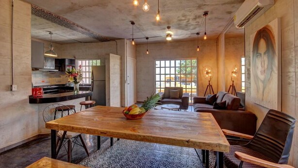 A spacious dining area with a wooden table, chairs, and a fruit bowl. - Comfortable apartment only 3 blocks from 5th av (Playa del carmen)