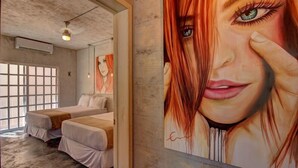 A room with two beds, a large window, and a painting on the wall. - Comfortable apartment only 3 blocks from 5th av (Playa del carmen)