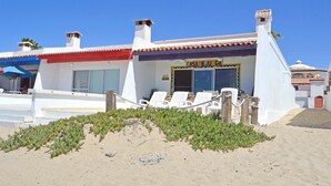 Een gebouw aan het strand met een bord waarop 'CASADEIUCAS' staat.