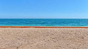 Une plage de sable fin, une mer d’un bleu limpide et une barrière de couleur orange.